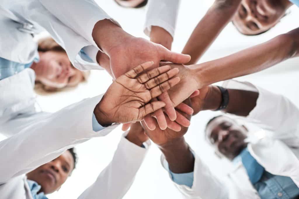 group of people with hands together at integrative health clinic an alternative health clinic