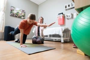 physical therapist with patient floor exercizes