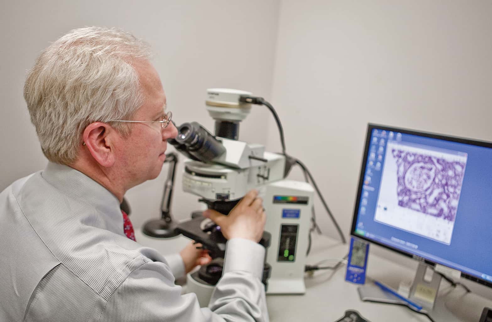dr. linzie with microscope and computer