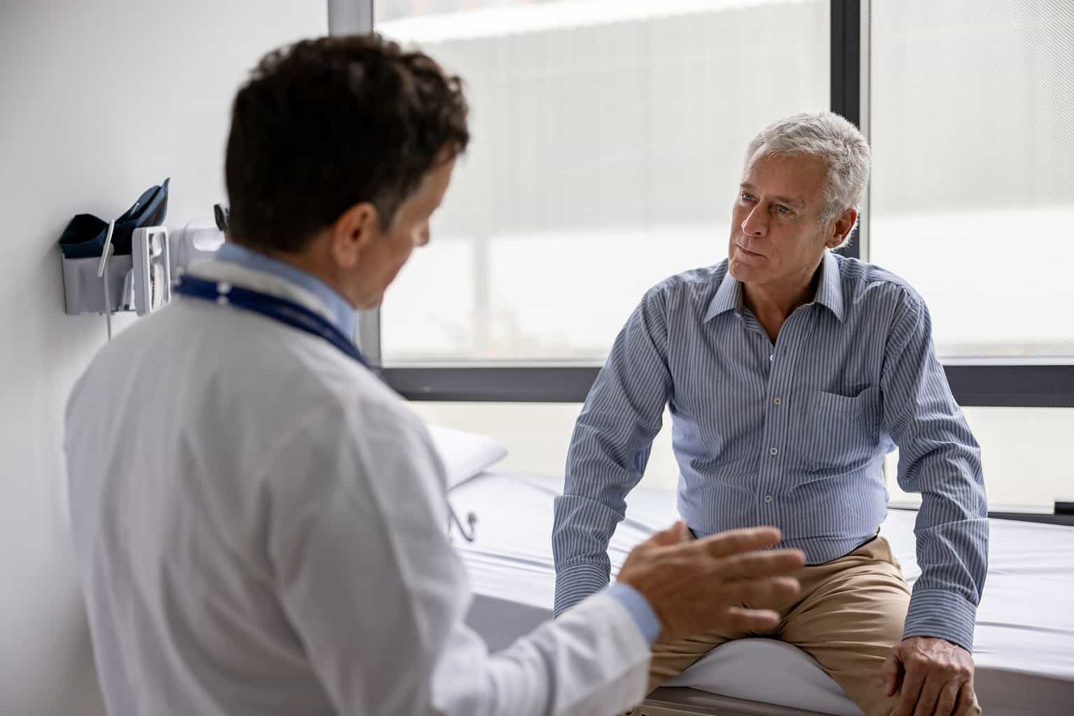 elderly Man with doctor in nephrology clinic and renal clinic discussing first kidney transplant