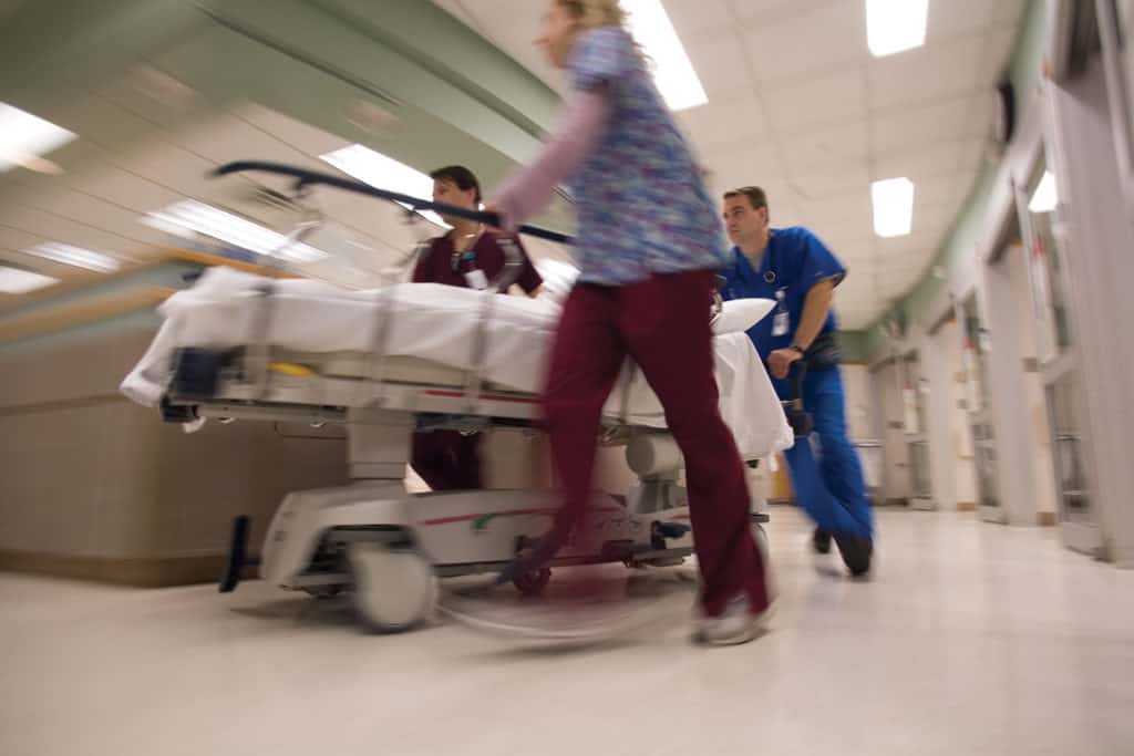 emergency medicine staff pushing patient in gurney