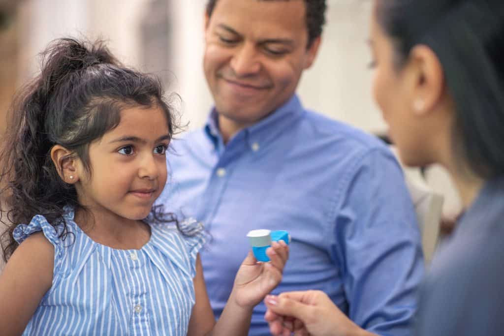 girl with parents and inhaler and asthma doctor seeking asthma videos, a printable allergy action plan PDF, asthma patient resources and resources for asthma patients
