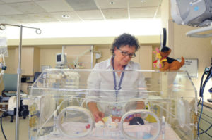 nicu nurse with baby in crib, nic u, nicu, nicu nurse, neonatal intensive care unit, neonatal intensive care