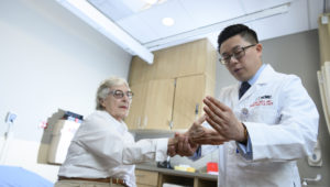 rheumatologist with elderly female patient in clinic room