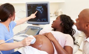 Tech with Young Couple Viewing Ultrasound, pre natal care, prenatal care, prenatal health, emergency medical for pregnancy, at home prenatal care