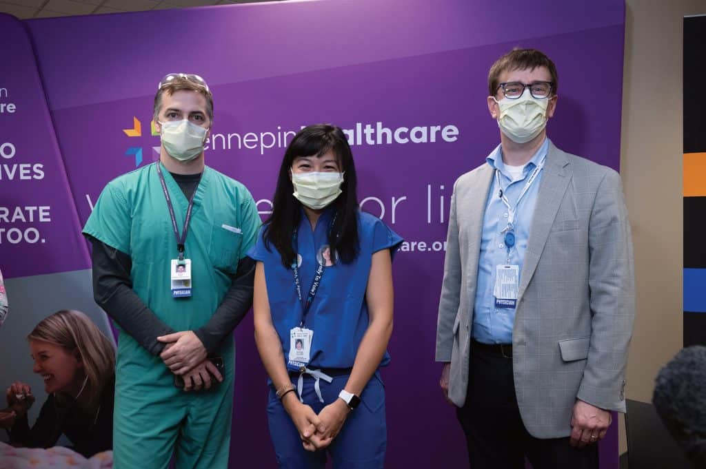 three masked employees showing their arm where they got the vaccine