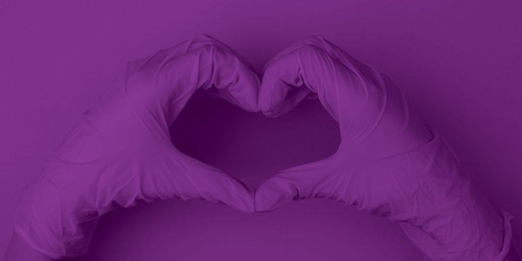 purple hands with surgical gloves making shape of heart