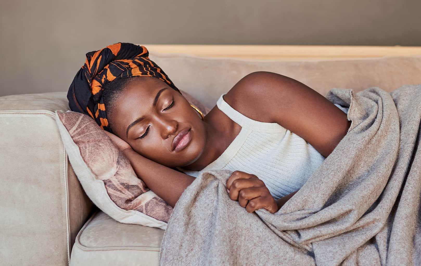 woman sleeping on couch who needs sleep tips on how to get to sleep and know wind down before bed meaning