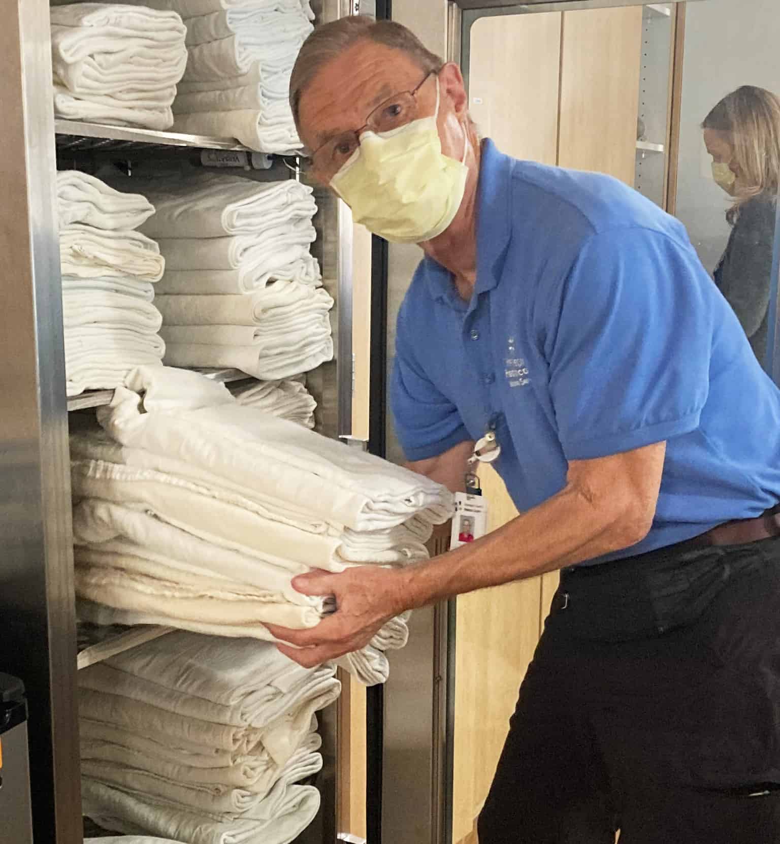 male volunteer stocking white towels