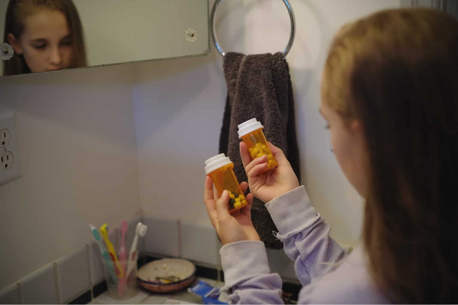 woman looking at pill bottle