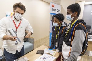 resident training two students during black men with stethoscopes event, Black Men with Stethoscopes, Youth Summit, Black/BIPOC youth, careers in medicine, real life medical simulations