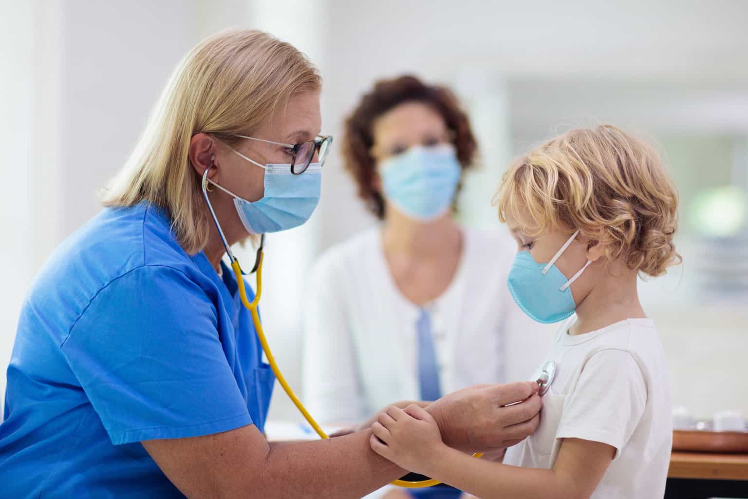 Doctor examining sick child in face mask for rsv virus