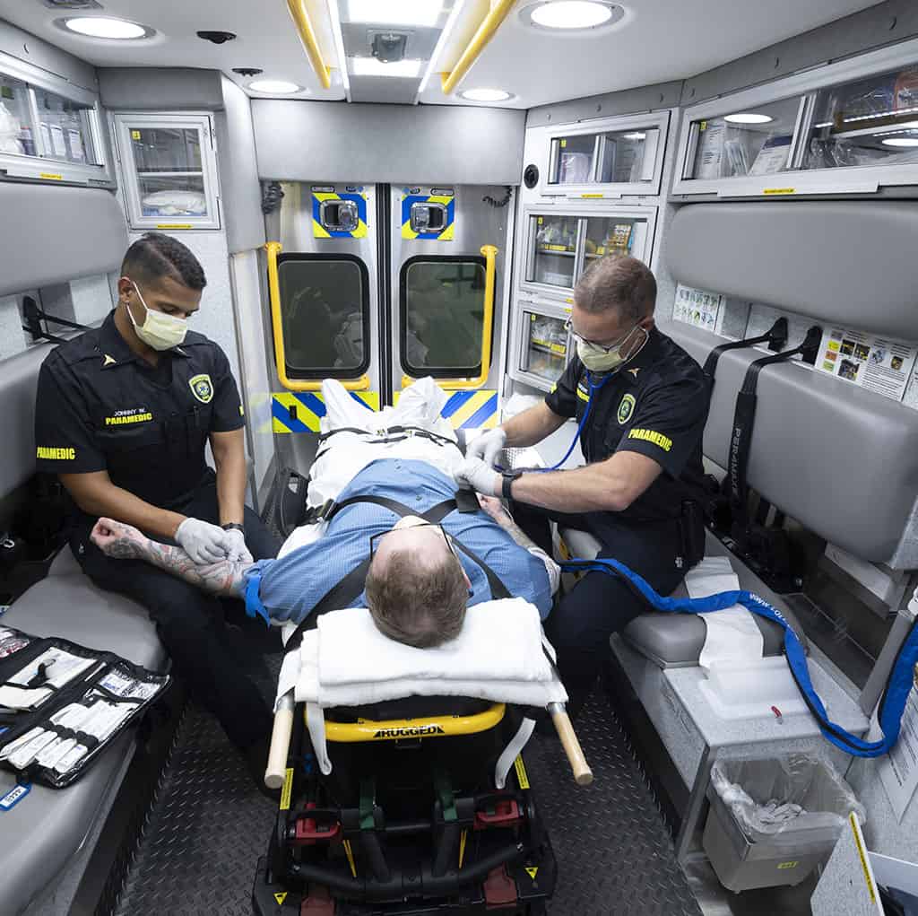 Two paramedics care for patient in ambulance
