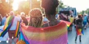 two women wrapped together in rainbow blanket at pride festival, lgbtq+ pride festival, loring park pride parade, transgender, twin cities pride festival, pride festival
