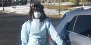 pam ruis with mask, shield, and gown next to her car, The closest to being cared for is to care for someone else, hospital visit, long term care, home health care nursing, a circle of trust