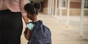 young girl anxious about going back to school holding her mom's hand, parent/guardian, student hates school, common causes of not liking school, bullying, anxiety, learning disabilities, kathy hakanson, child psychiatrist