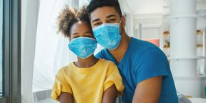 dad and son both wearing masks, here for families, pediatric care in the midst of a pandemic, prevent the spread of COVID-19, stay up to date with vaccinations, keeping kids healthy during covid19