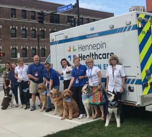 hennepin ems staff and dogs in front of ambulance, hennepin ems welcomes 4-legged members, hennepin heroes program, paw patrol, volunteer canines, north star therapy animals