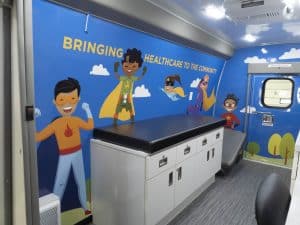 pediatric mobile van interior with kid graphics on wall, mobile clinic brings health care to patients' doors, mobile van healthcare, routine vaccines, pediatric mobile health team, childhood immunizations, bridge a healthcare gap