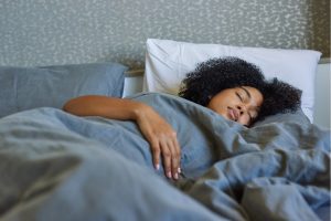 young black woman sleeping, sleep cycles, rem, six sleep cycles, healthy sleep, how sleep affects health, rapid eye movement