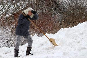 older woman shoveling heavy snow, shoveling snow, heart attack triggers, stressful work for heart, protect your heart, snow shoveling may trigger heart attack
