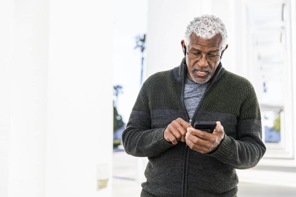 older man looking at his heart app on his smart phone, Cardiac rehab in an app, cardiac rehabilitation, strengthen the heart, relieve symptoms, decrease readmission rates, annual heart walk