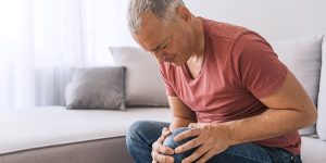 older man holding knee and showing pain, managing arthritis, inflammation, pain in joints, osteoarthritis, rheumatoid arthritis, swelling, dr rawad nasr