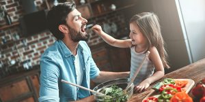young man with daughter feeding him healthy food, want a healthy heart, diet and exercise, salt substitutes, healthier fats, whole grains, elizabeth rosenstein, dietitian, exercise, good sleep habits