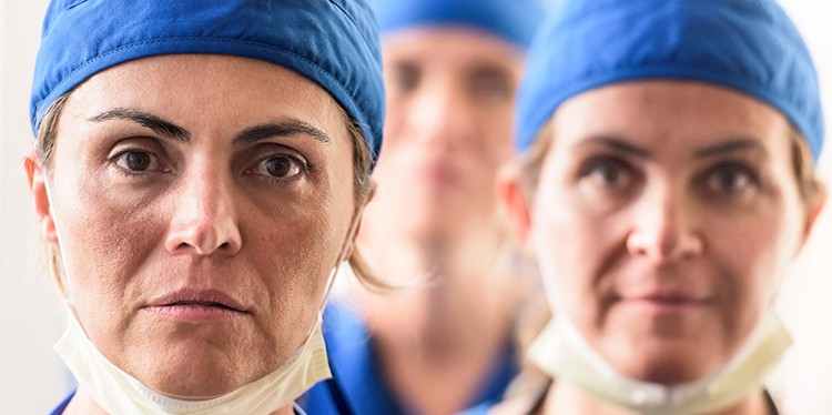 Three female surgeons posing serious looking at the camera, doctors without borders