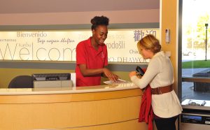 welcome desk staff helping patient find her clinic, find patient care, primary and specialty clinics, welcome staff, connected hospital buildings, discounted parking