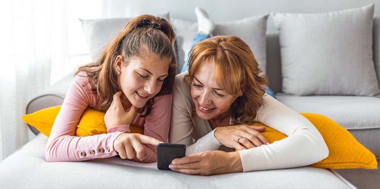 teen girl with mom looking at smartphone together, spending time with your teen, teen support system, healthy relationship with parent and teen