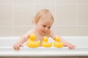 A Baby Boy Looking At A Row Of Rubber Ducks