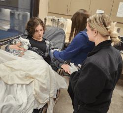 two emt students with patient on gurney learning how to take blood pressure, emts embark on intensive training course, domestic call turns into a labor and delivery, assessing the situation, emt license, emt training course, emergency medical care and transportation