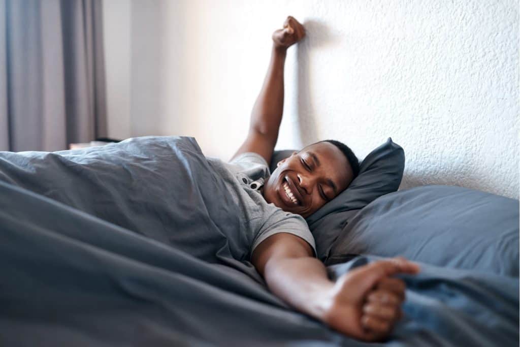 man waking up from a relaxing night of sleep