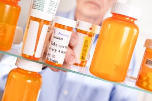 Man taking prescription pills out of medicine cabinet