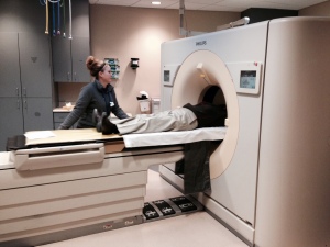 radiology tech with patient and CT scan machine